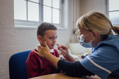 Child receiving flu vaccine at school.