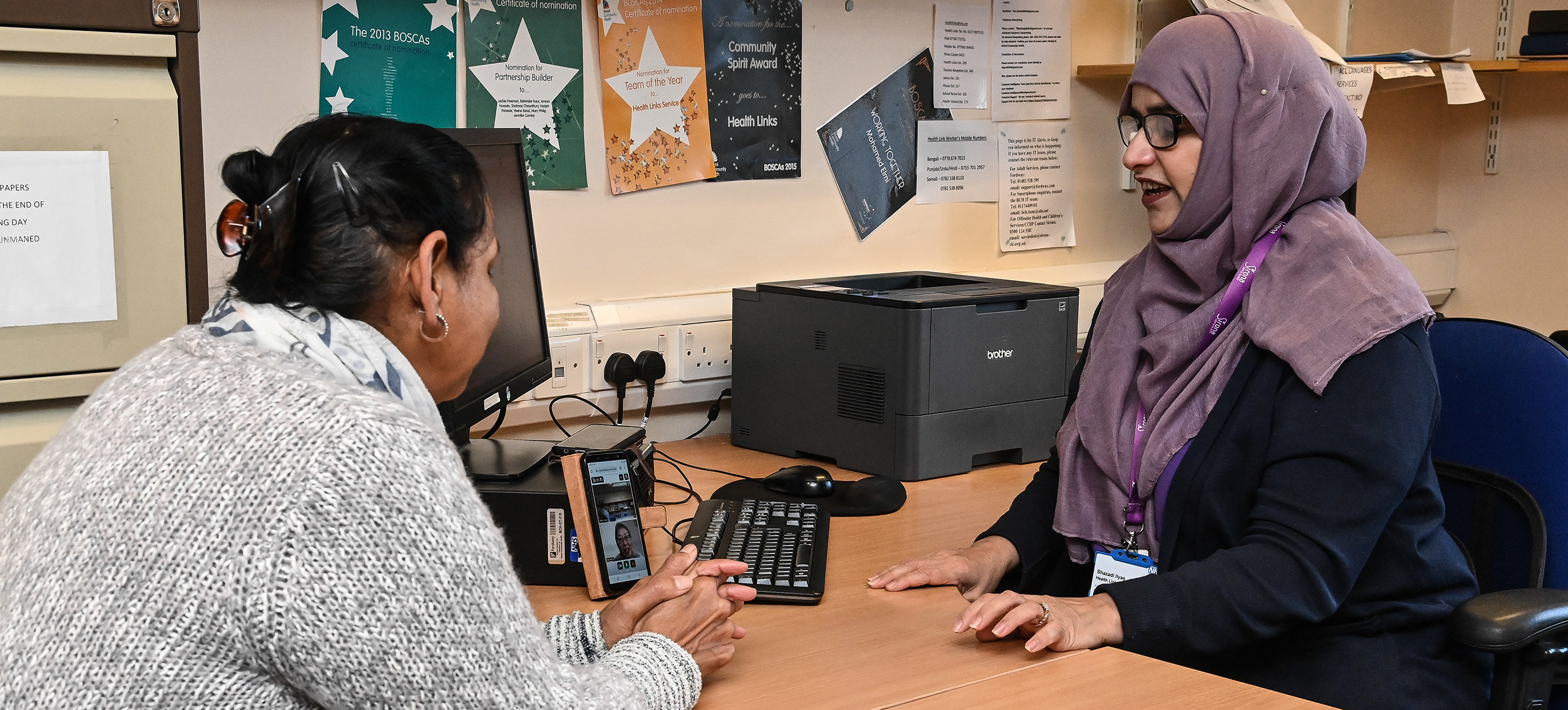 Clinicians speaking with woman in office.