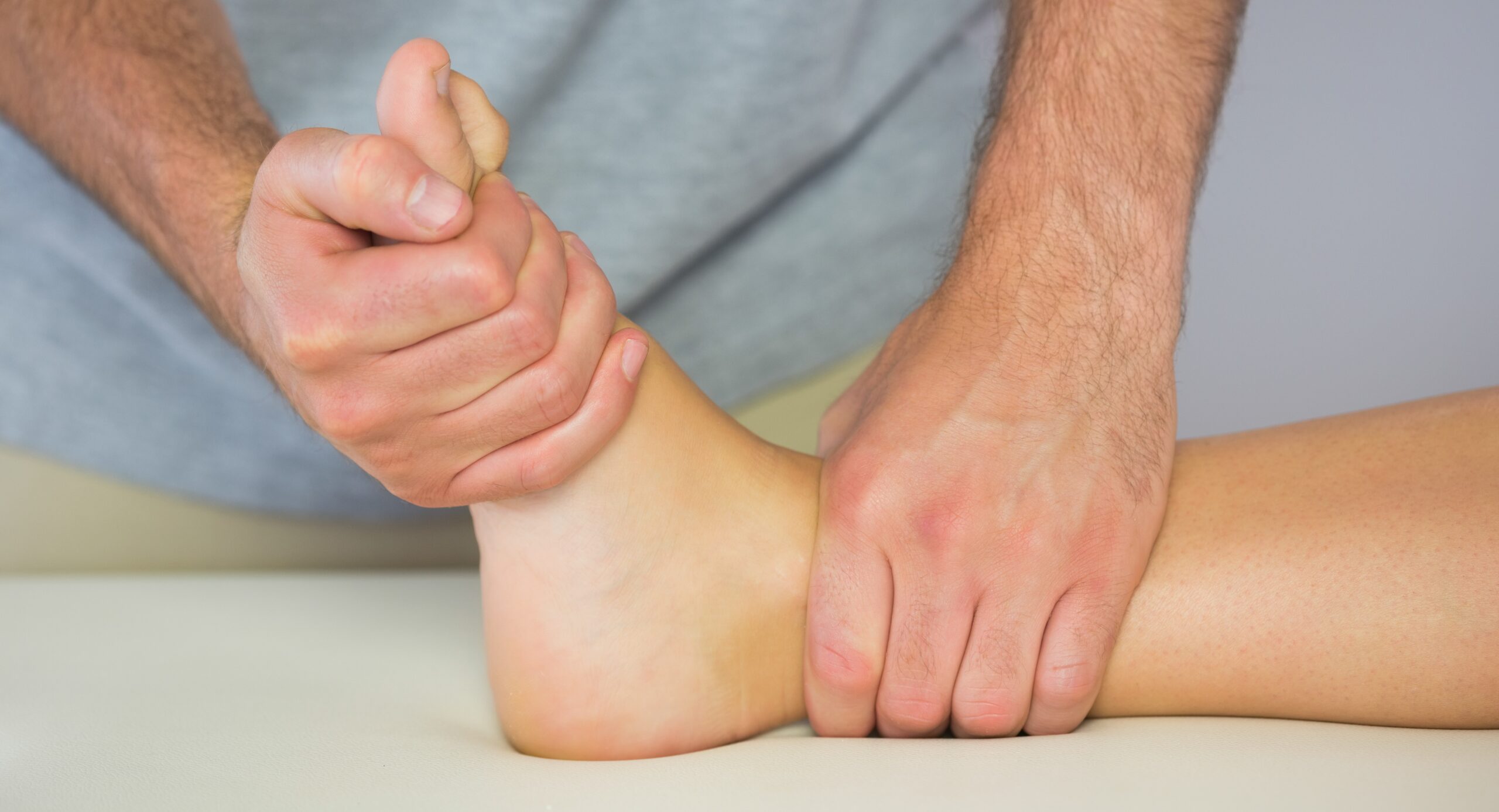 Physio providing treatment to ankle and foot.