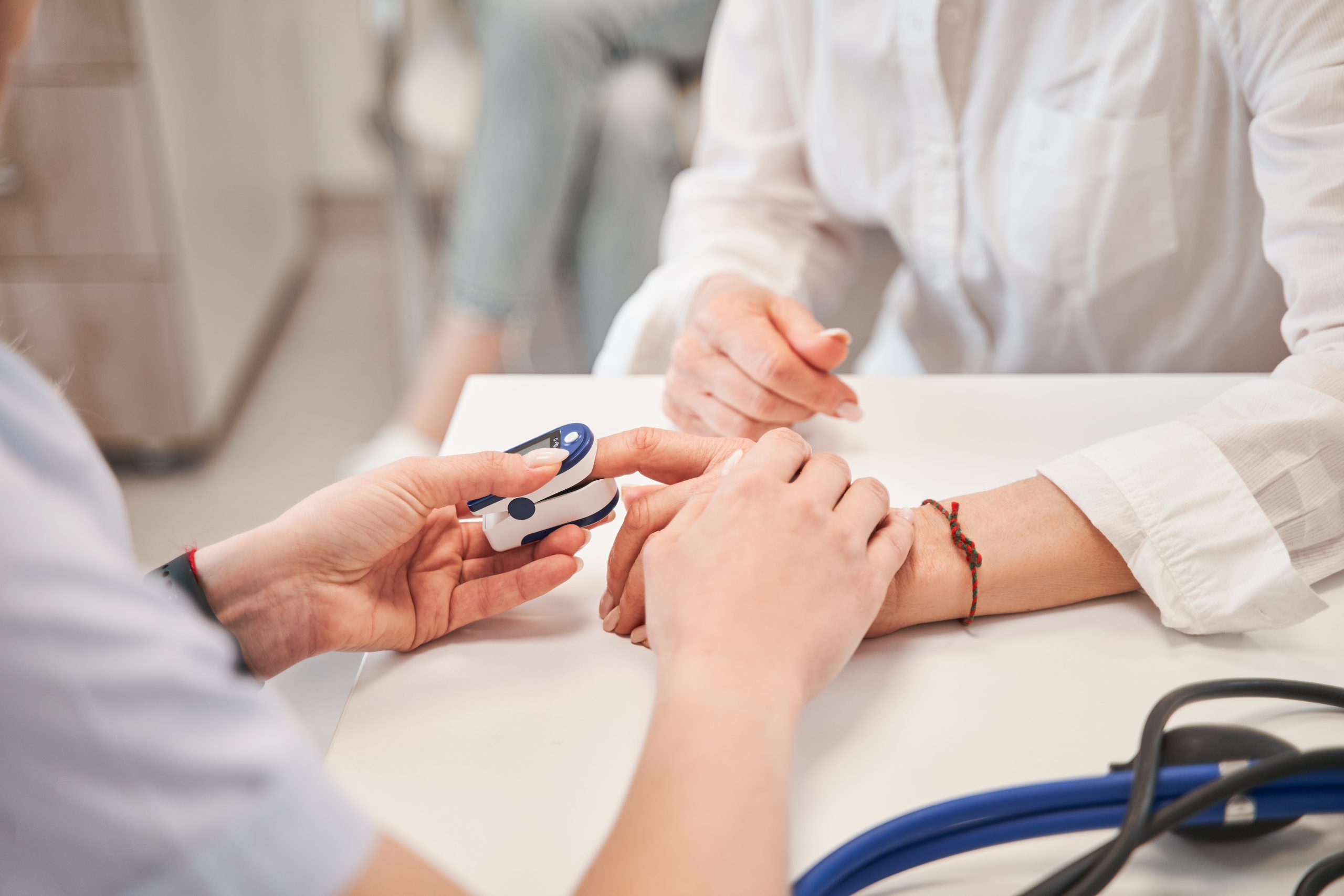 Nurse checking woman's blood sugar level.