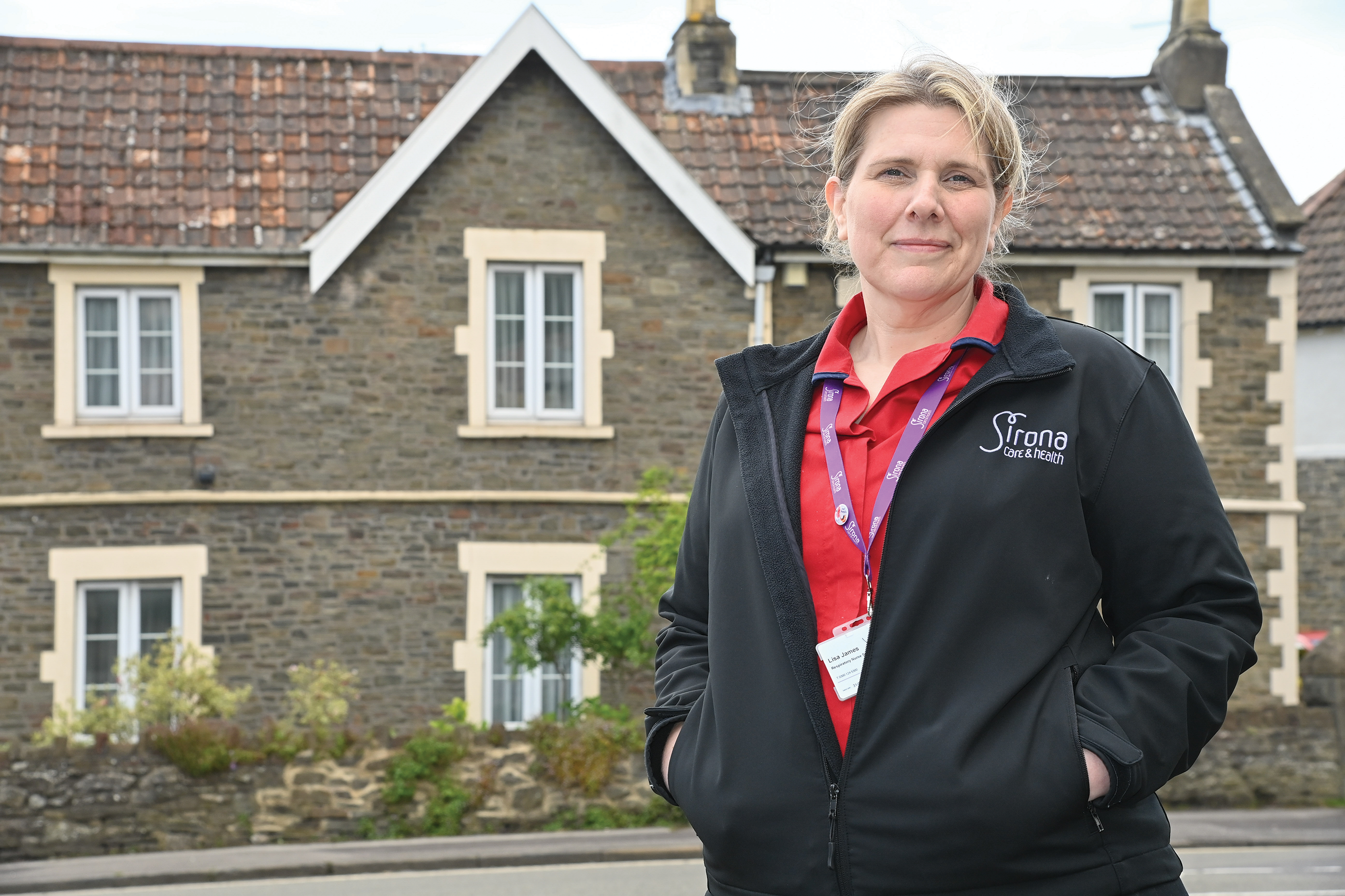 Clinician standing by house.