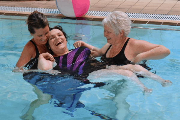 Physio helping girl in pool