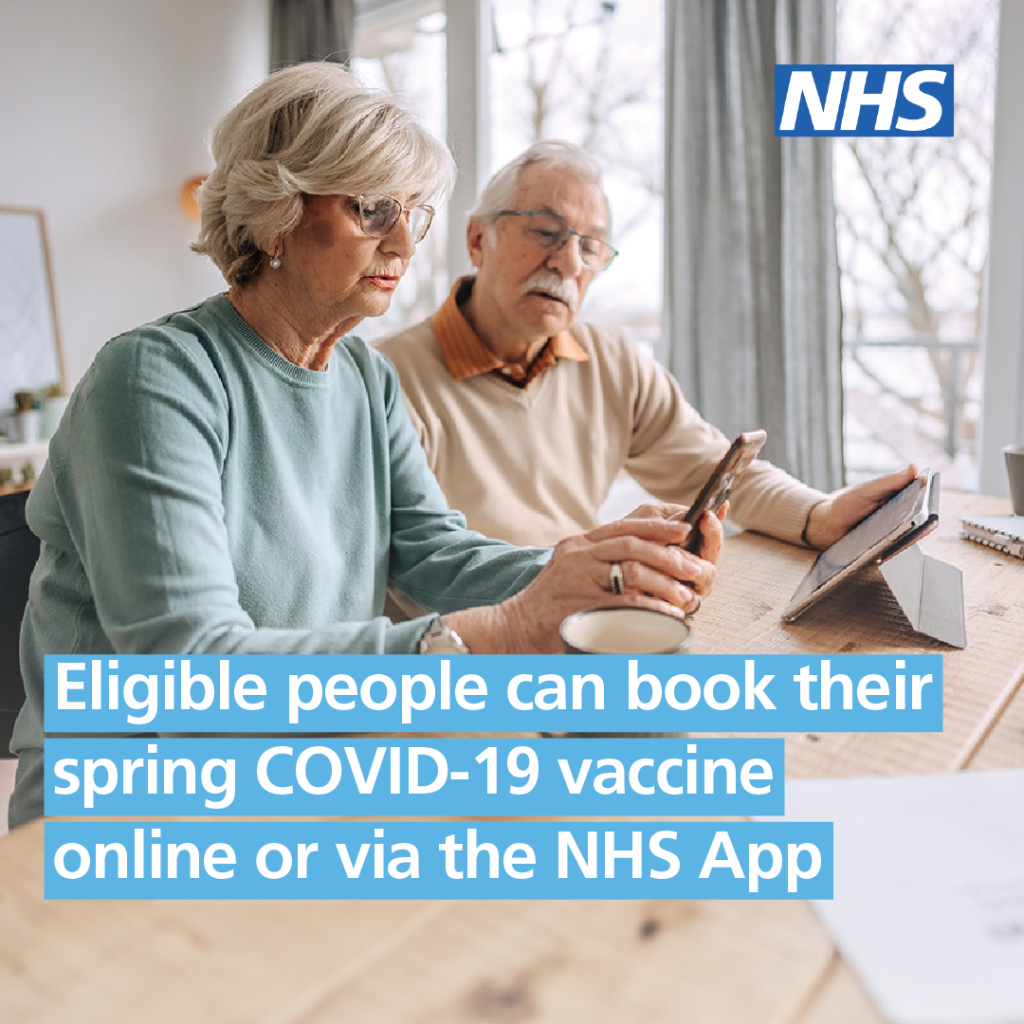 Two older people looking at their phone and a tablet. Overlaid is the NHS logo and test that reads: "Eligible people can book their spring covid-19 vaccine online or via the NHS App."