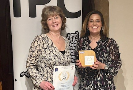 Picture of two Partner2Care staff holding award