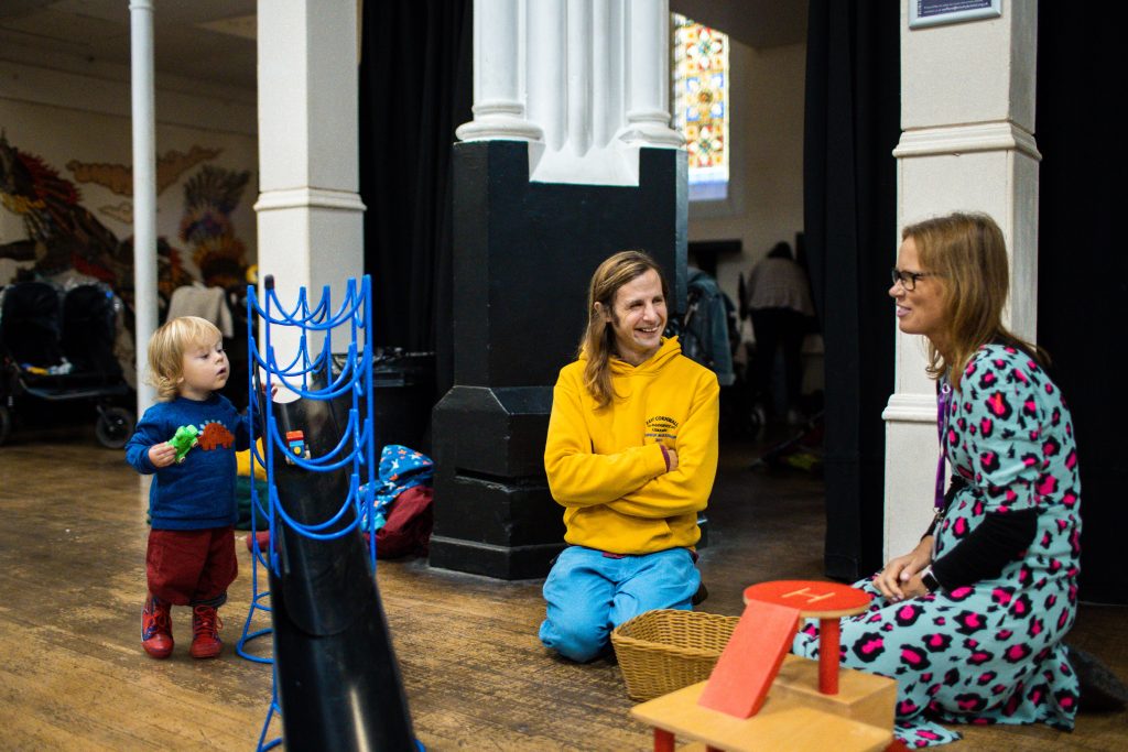 A dad and child talking to a health visitor at the Trinity Centre Baby Hub in Easton.