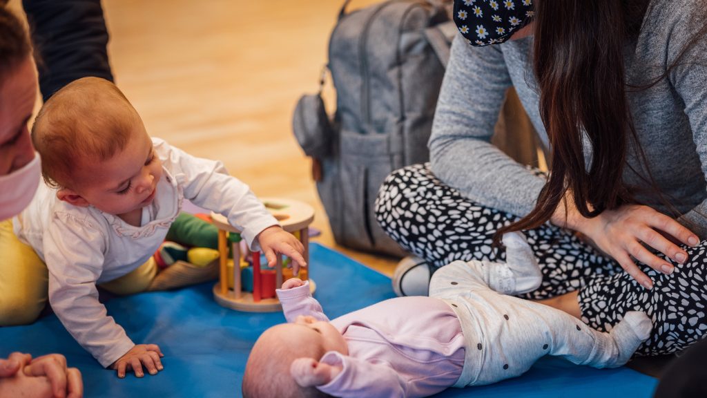 Two babies on a play mat at a baby hub.