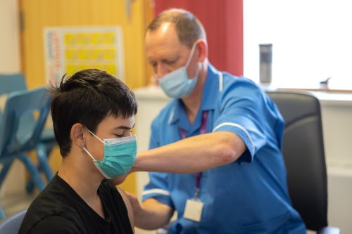 Teenage boy receiving HPV vaccine from a member of our School Aged Immunisation Team.