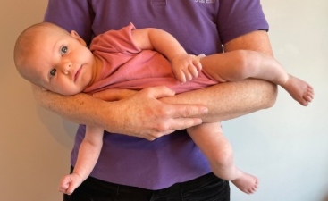 Baby awake being carried.