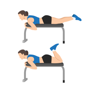 A person lies face down on a bench and bends one knee to lift the foot upward, demonstrating a prone hamstring curl exercise.
