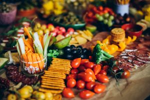 Vibrant display of fresh fruits, vegetables, crackers, and meats perfect for a party platter.